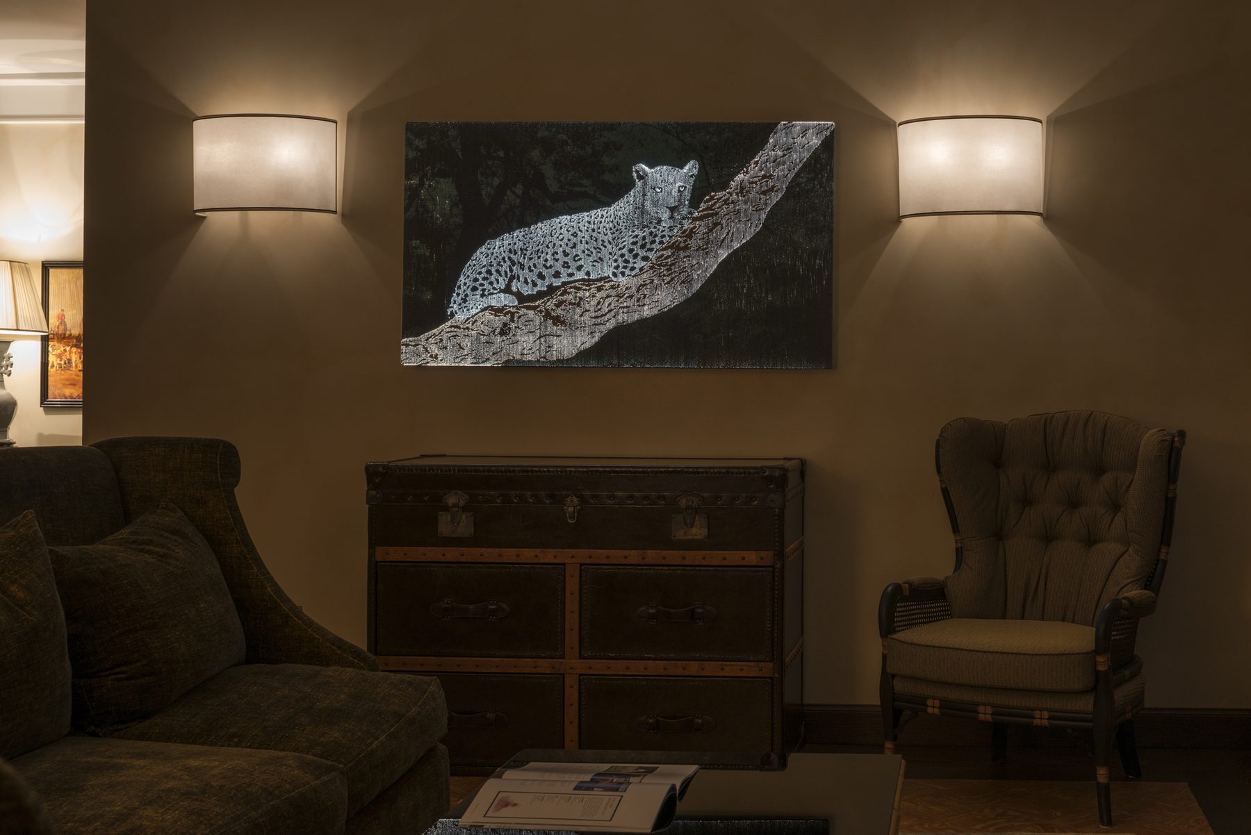 Cheetah art panel illuminated above a fireplace