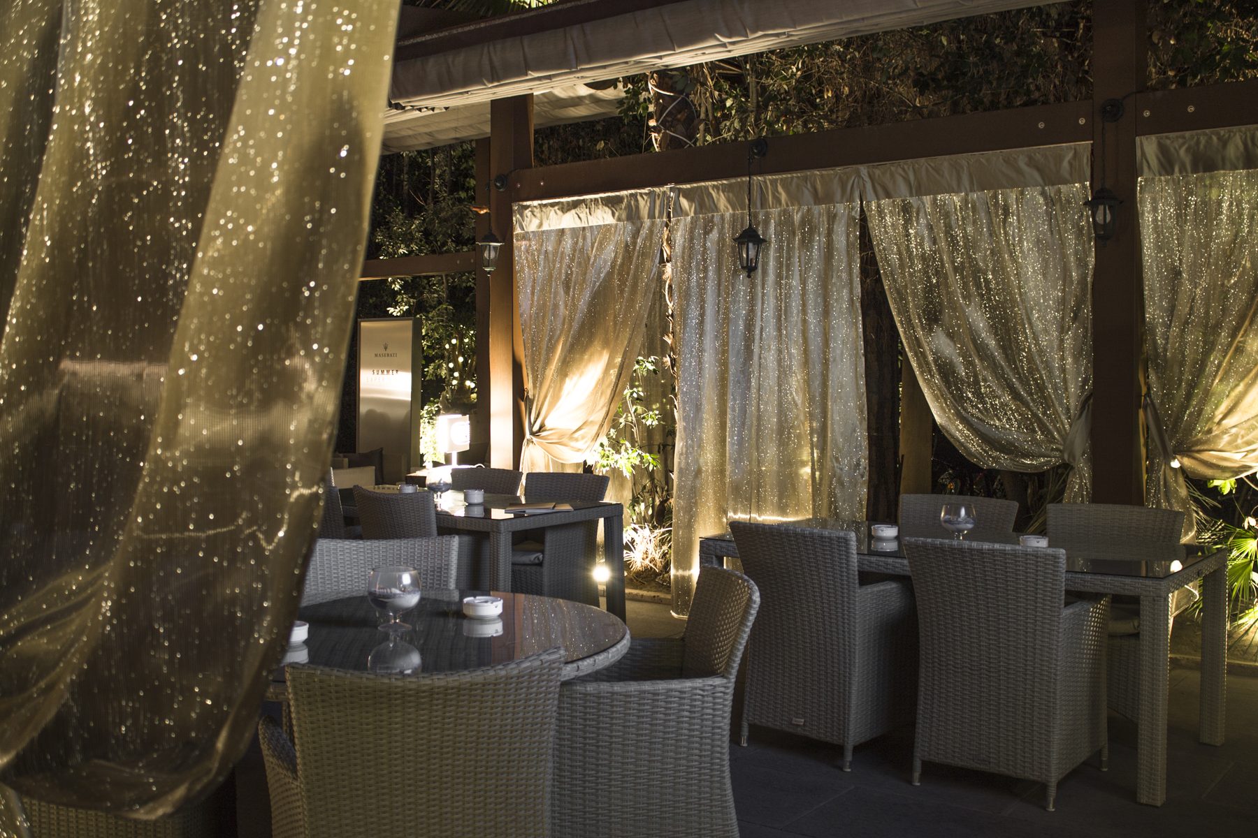 Illuminated sheer curtains on a lounge terrace at night